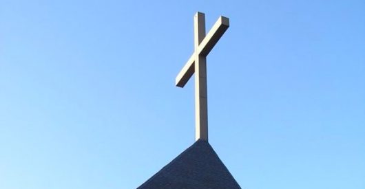 Photograph of cross on roof of church